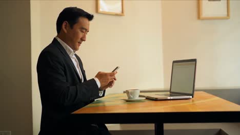 Businessman-using-mobile-phone-at-table-4k