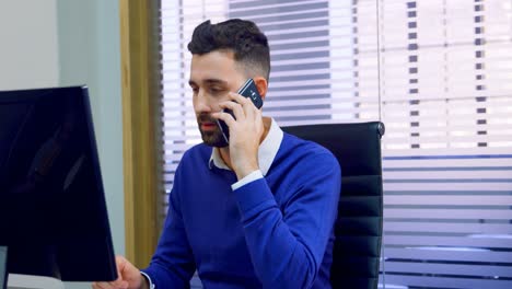Executive-talking-on-mobile-phone-at-desk-4k