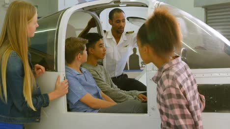 Male-pilot-explaining-about-aeroplane-to-kids-4k