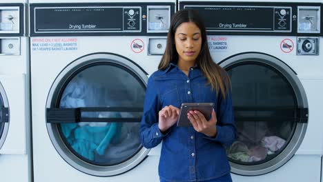Woman-using-digital-tablet-at-laundromat-4k