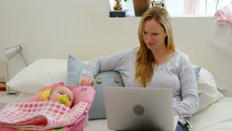 Mutter-Schaut-Ihr-Baby-An,-Während-Sie-Laptop-4K-Benutzt