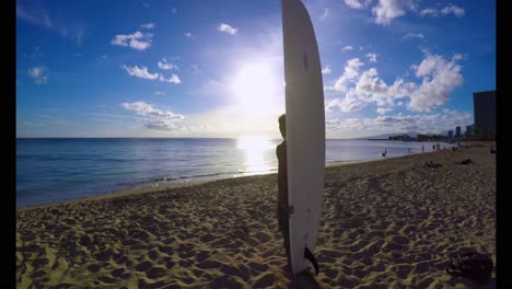 Surfer-with-a-surfboard-standing-on-the-beach-4k