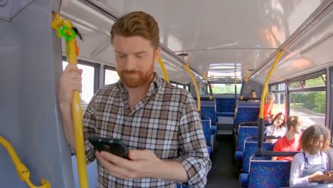 Man-using-mobile-phone-while-travelling-on-bus-4k