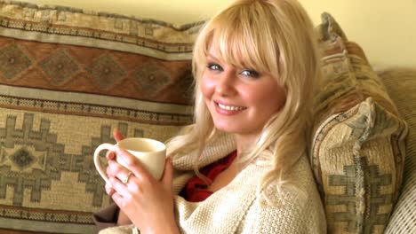 Porträt-Einer-Blonden-Frau,-Die-Kaffee-Trinkt-Und-Auf-Dem-Sofa-Sitzt