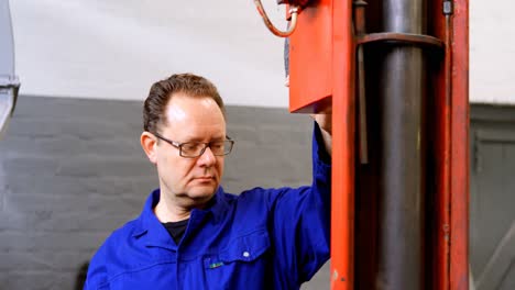 Mechaniker-Mit-Hydraulischem-Aufzug-In-Der-Garage-4k
