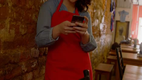 Female-baker-using-mobile-phone-in-bakery-shop-4k