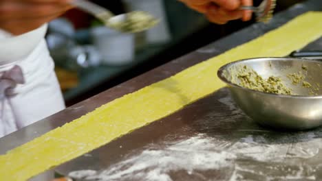 Male-baker-putting-ingredients-on-pasta-dough-4k