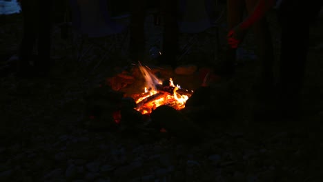 Group-of-hikers-lighting-sparkler-near-campfire-4k