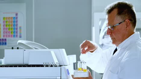 Male-scientist-placing-medical-vials-on-a-rack-4k