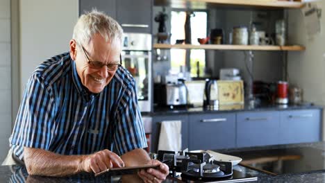Senior-man-using-mobile-phone-in-kitchen-4k