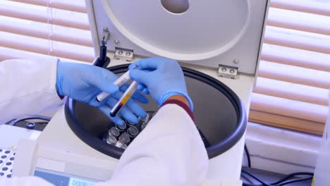 Doctor-taking-out-blood-samples-from-centrifuge-4k