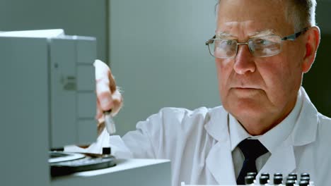 Male-scientist-placing-test-tube-on-a-machine-4k
