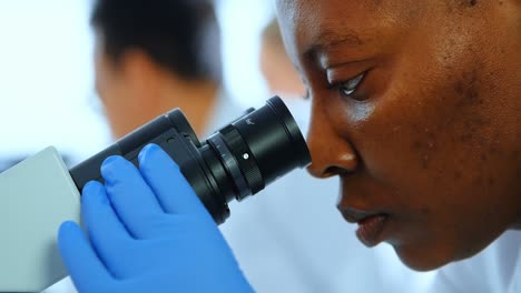 Científica-Femenina-Usando-Microscopio-En-Laboratorio-4k