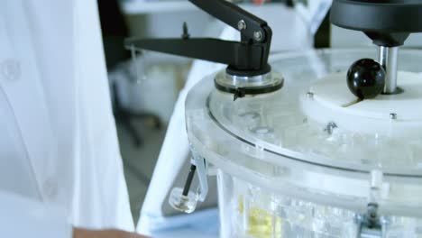Male-scientist-using-centrifuge-machine-in-laboratory-4k