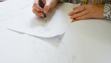 Fashion-designer-drawing-sketch-in-fashion-studio-4k