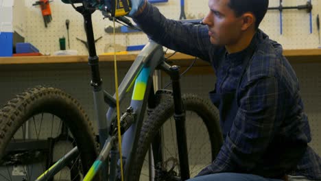 Man-repairing-bicycle-in-workshop-4k