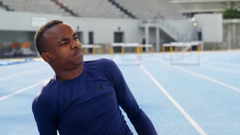 Disabled-athletic-frowning-in-pain-on-running-track-