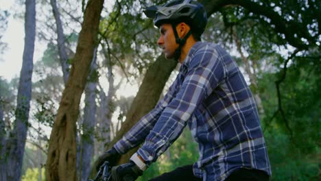 Man-using-smartwatch-while-sitting-on-bicycle-4k