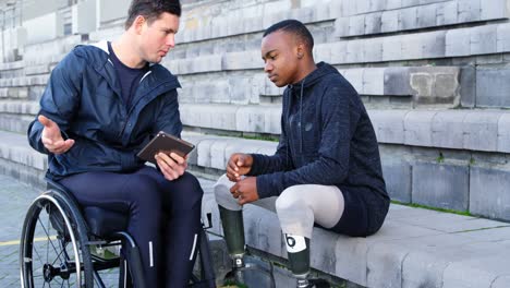 Two-disabled-athletics-discussing-over-digital-tablet-4k