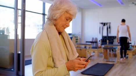 Ältere-Frauen-Benutzen-Mobiltelefon-Im-Yoga-Zentrum-4k