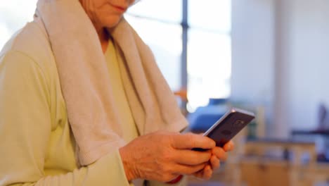 Senior-women-using-mobile-phone-in-yoga-center-4k