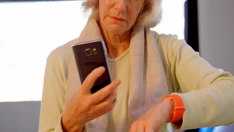 Ältere-Frauen-Nutzen-Mobiltelefon-Und-Smartwatch-4k