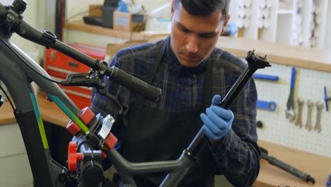 Man-repairing-bicycle-in-workshop-4k