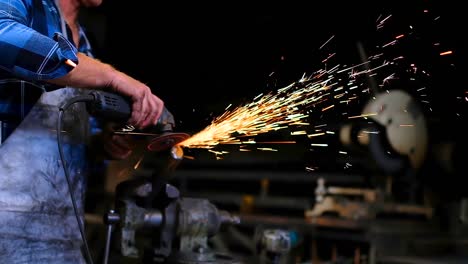 Blacksmith-using-grinder-in-workshop-4k