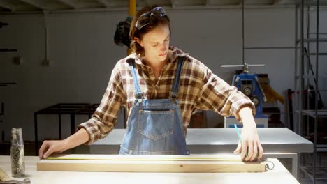 Carpenter-measuring-wooden-plank-in-workshop-4k