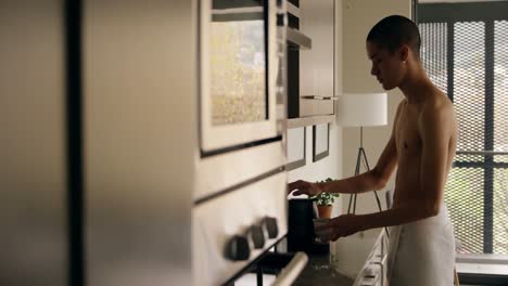 Man-using-coffee-maker-machine-at-home-4k