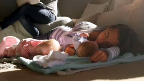 Mother-sleeping-her-baby-boys-in-living-room-4k
