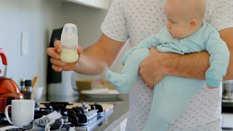 Father-holding-his-baby-boy-in-kitchen-4k