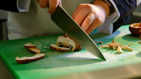 Chef-cutting-mushroom-in-kitchen-4k