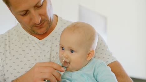 Father-feeding-water-to-his-baby-boy-4k
