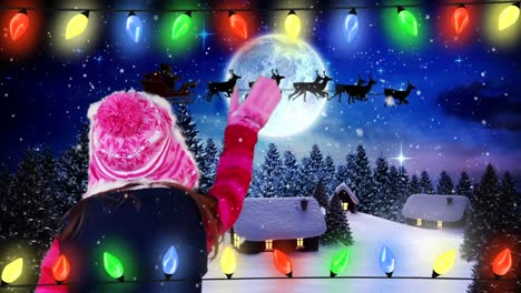 Girl-waving-at-Santa-and-reindeer-in-sleigh-over-Christmas-Winter-landscape
