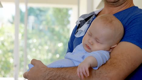 Baby-boy-sleeping-in-his-father-arm-4k
