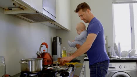 Padre-Con-Su-Bebé-Preparando-Comida-En-La-Cocina-4k