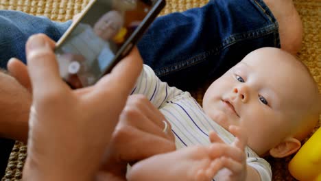 Father-taking-picture-of-his-baby-boy-at-home-4k