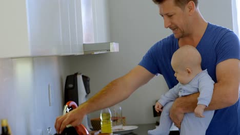 Father-with-his-baby-boy-preparing-food-in-kitchen-4k