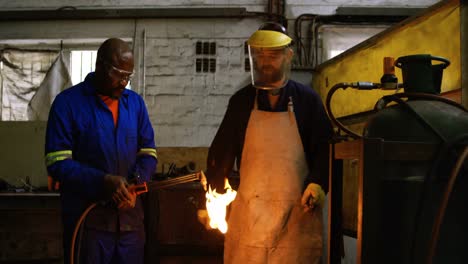 Metalsmiths-lighting-welding-torch-in-workshop-4k