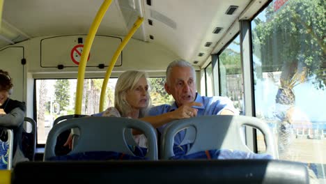 Senior-couple-interacting-with-each-other-while-travelling-in-bus-4k