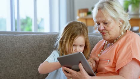 Grandmother-and-granddaughter-using-digital-tablet-4k