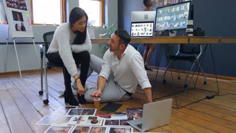 Male-and-female-graphic-designers-discussing-over-photographs-4k
