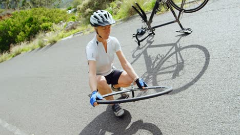 Senior-cyclist-repairing-bicycle-at-countryside-4k