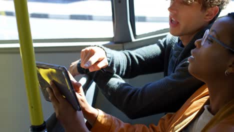 Couple-using-digital-tablet-while-travelling-in-bus-4k
