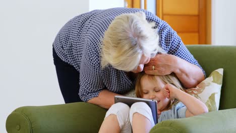 Großmutter-Und-Enkelin-Nutzen-Digitales-Tablet-Im-Wohnzimmer-4K
