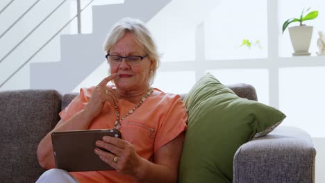 Senior-woman-using-digital-tablet-in-living-room-4k