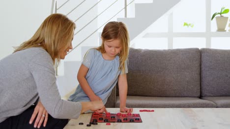 Mother-and-daughter-playing-board-game-on-table-4k