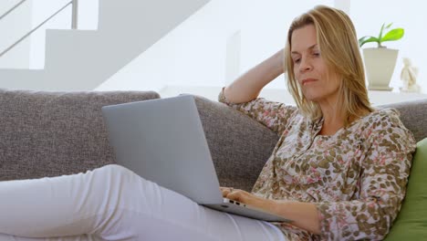 Woman-using-laptop-in-living-room-4k