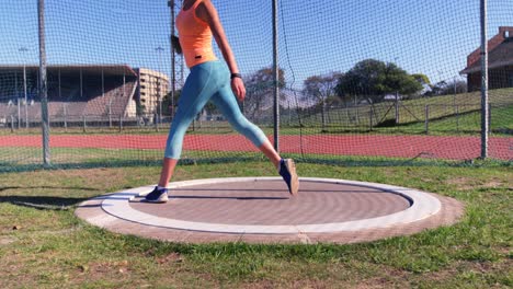 Side-view-of-Caucasian-female-athlete-practicing-discus-throw-at-sports-venue-4k